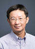 Mason professor Chun-Hung Chen wears a light, blue-collared shirt, glasses, and smiles in his profile